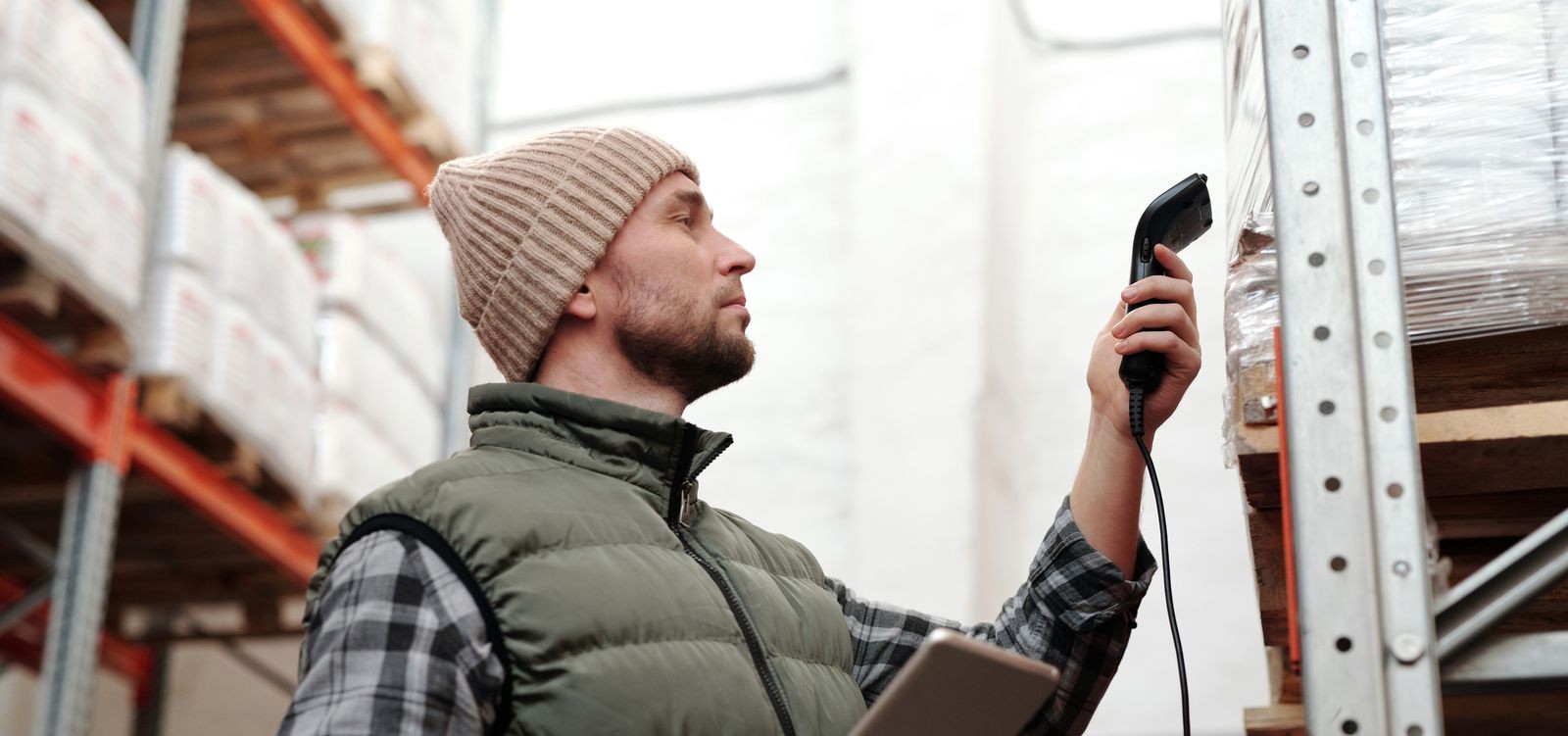 Warehouse worker scanning inventory with a handheld scanner and tablet
